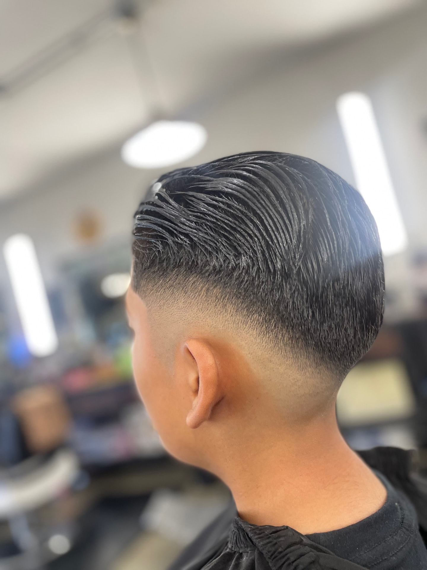 Slicked hairstyle with a precise fade by Daniel