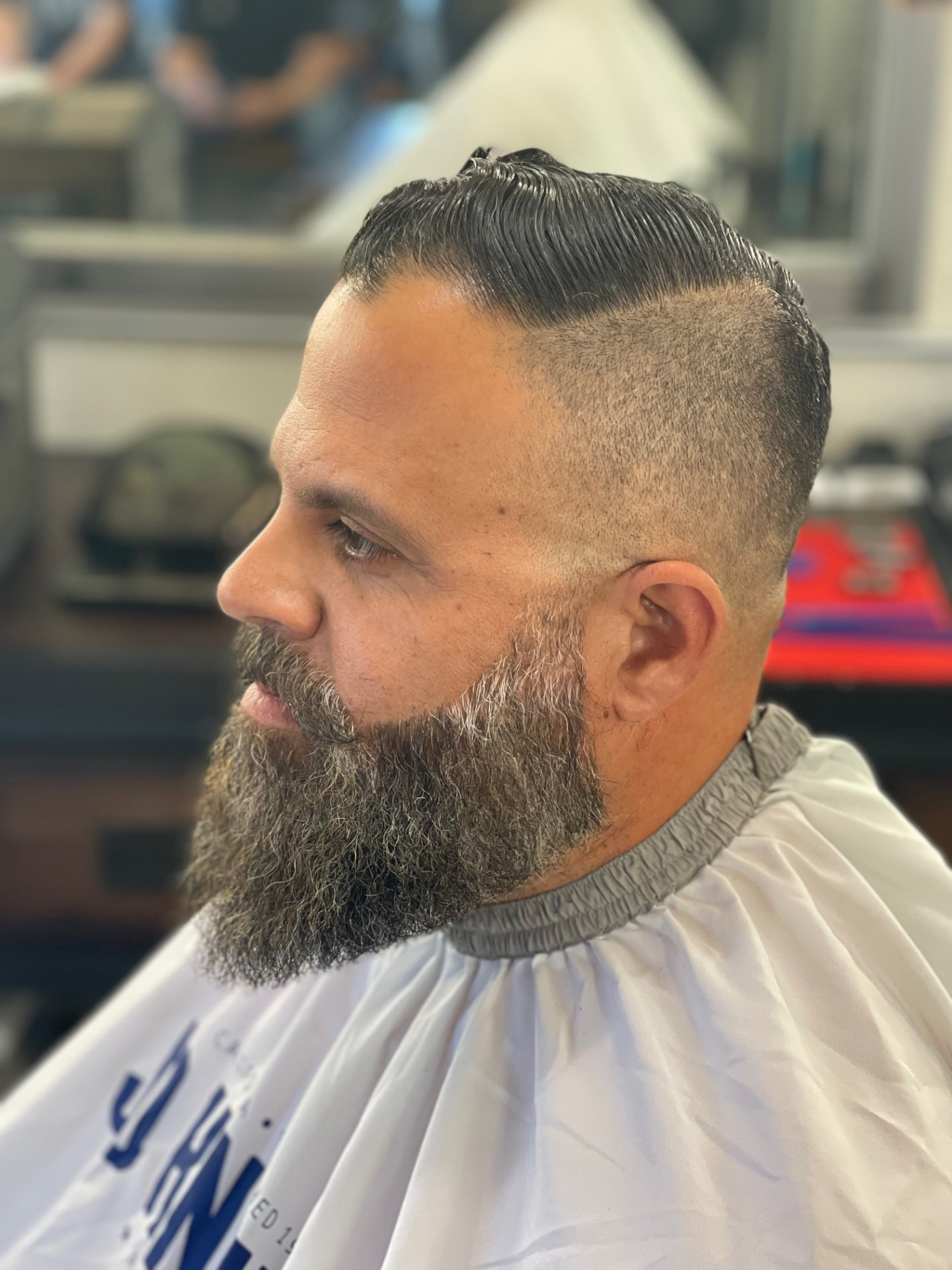 Classic side-part haircut and full beard grooming by Ruben