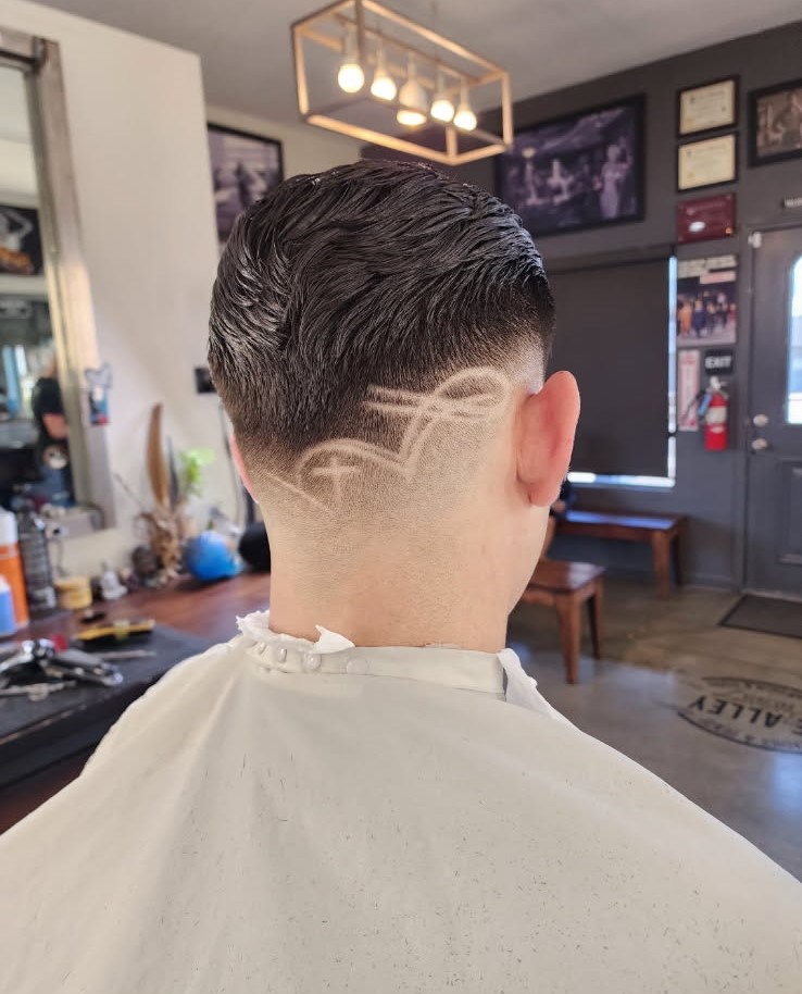 Textured fade with a detailed shaved design by Jerry