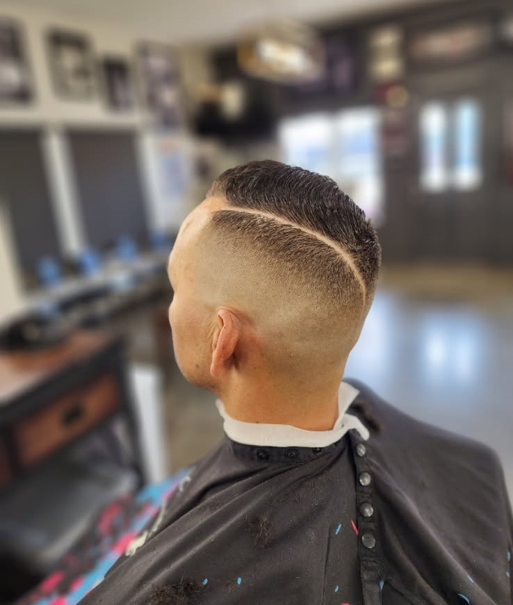 Clean skin fade with a precise hard part by Jerry